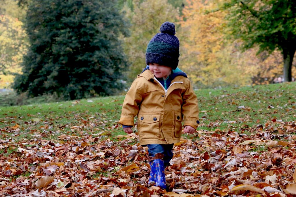 child walking through leaves