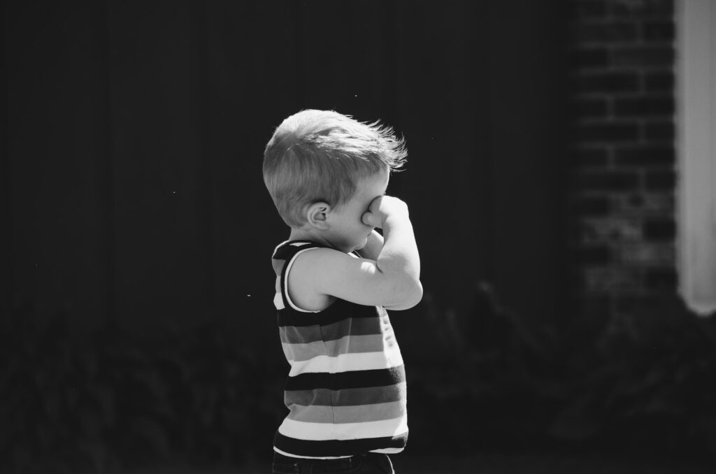 child wiping his eyes